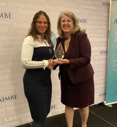 Maribel Vazquez holding award with another woman