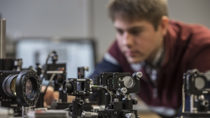 Cameras and instrumentation in research lab with young white male in background.