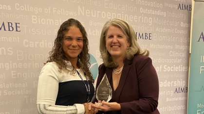 Maribel Vazquez holding award with another woman