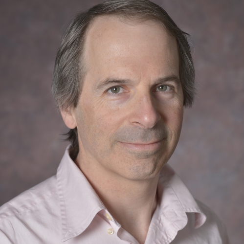 head shot of man with light brown hair wearing a light pink button down shirt