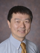 head shot of asian male with short black hair wearing a light blue shirt with a gold tie