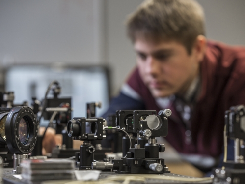 Cameras and instrumentation in research lab with young white male in background.