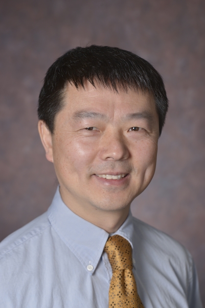 head shot of asian male with short black hair wearing a light blue shirt with a gold tie
