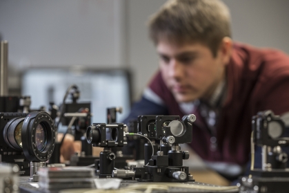 Cameras and instrumentation in research lab with young white male in background.